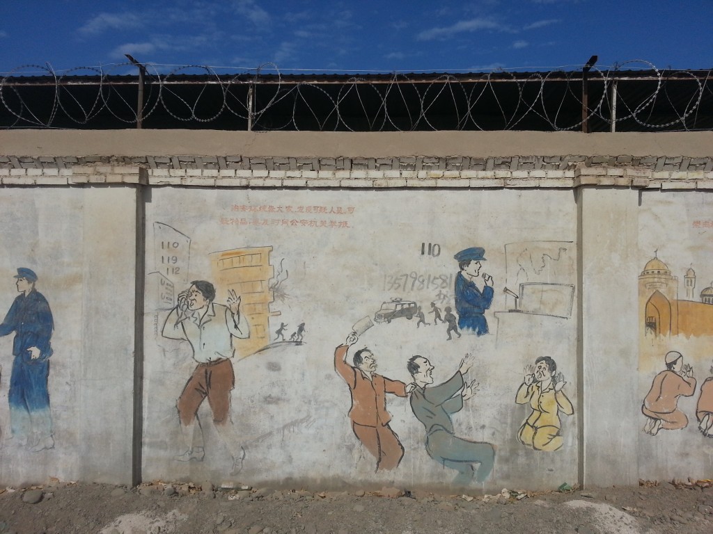 In this one, one man is attacking another man with a butcher knife (in Xinjiang, this happens often, as a manifestation of ethnic tensions). As the victims wife screams, a neighbor is calling the police, who immediately dispatch a patrol car. The caption in the top right corner reads, "Maintaining public security depends on everyone. If you discover suspicious persons or things, promptly call the public security organs to report it."