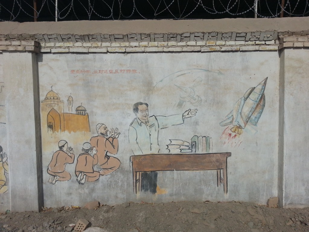 The message of this painting is less obvious. The caption reads, "Venerate Science, Oppose Superstition, Oppose Cults." On the right is a man who looks fairly Han Chinese. He is standing behind his well-booked desk, and he is gesticulating towards a space shuttle and a satellite. To this man's left are three people praying on their knees in front of a mosque, looking towards the science man. I am not clear on whether these propagandist are really suggesting that Islam is a cult and that praying is a kind of superstition.  