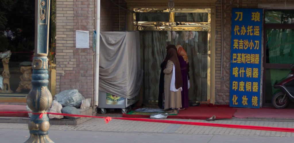 Fully covered women worshipin in an alcove to the side